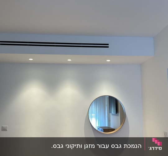 קיר גבס עם מראה עגולה ותאורה שקועה